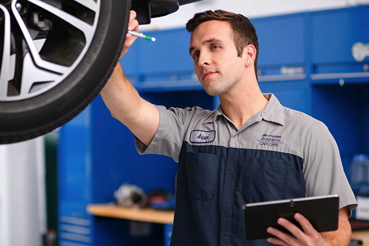 Hyundai service technician inspecting a vehicle