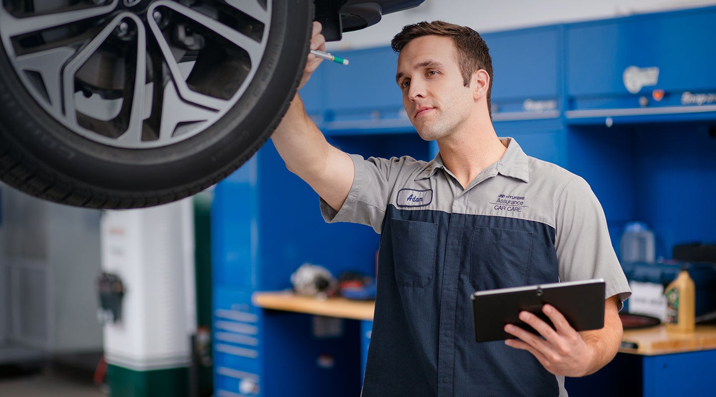 Hyundai-certified service technician inspecting a vehicle at Leo Hyundai of Columbus